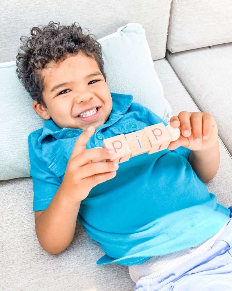 Boy learing reading using a phonics toy by Little Bud Kids