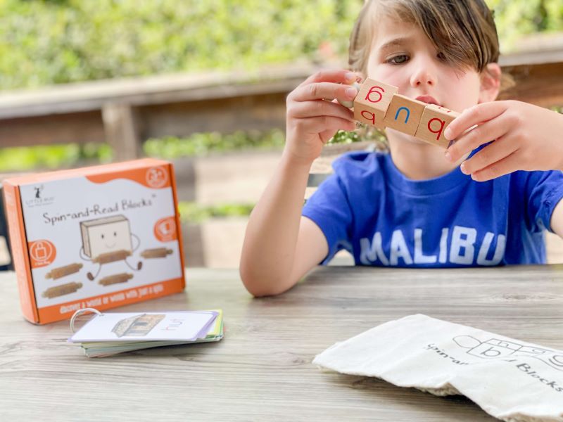 Boy learning reading using Little Bud Kids Spin-and-Read Phonics toy