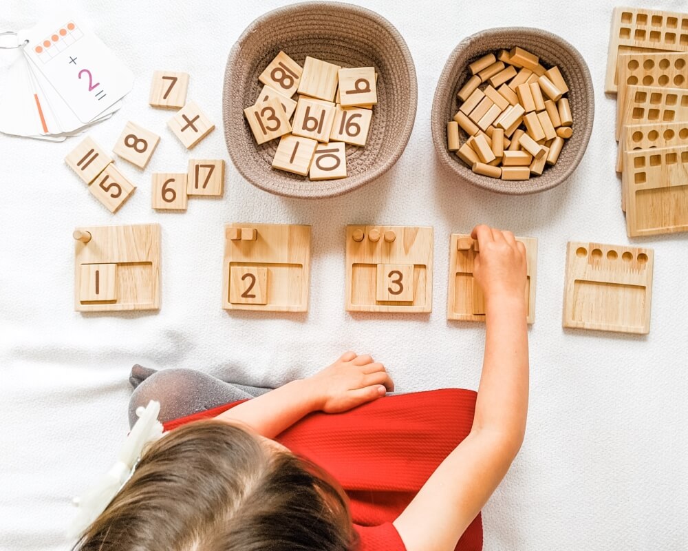 Girl learning how to count using Counting Pegs Math Panels by Little Bud Kids