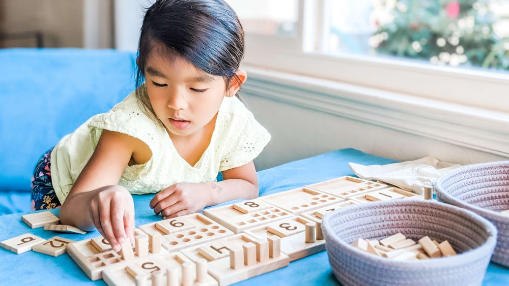 Asian girl playing with Counting Pegs Math Toy by Little Bud Kids