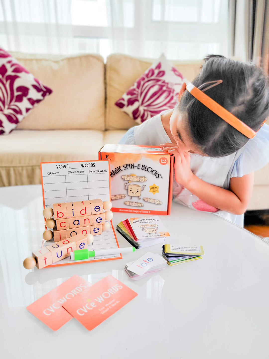Girl showing her silent E phonics toy, a material designed to practice CVCe words and long vowel sounds.