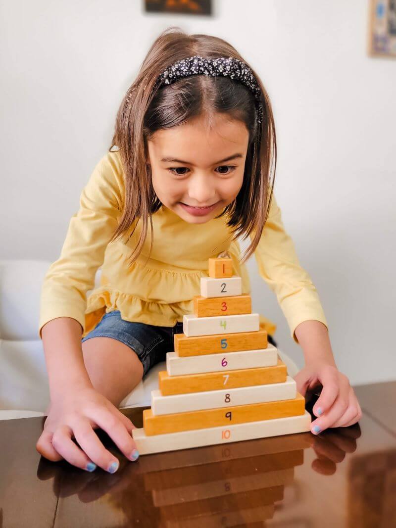 Girl stacking Montessori Numerical Rods from Little Bud Kids
