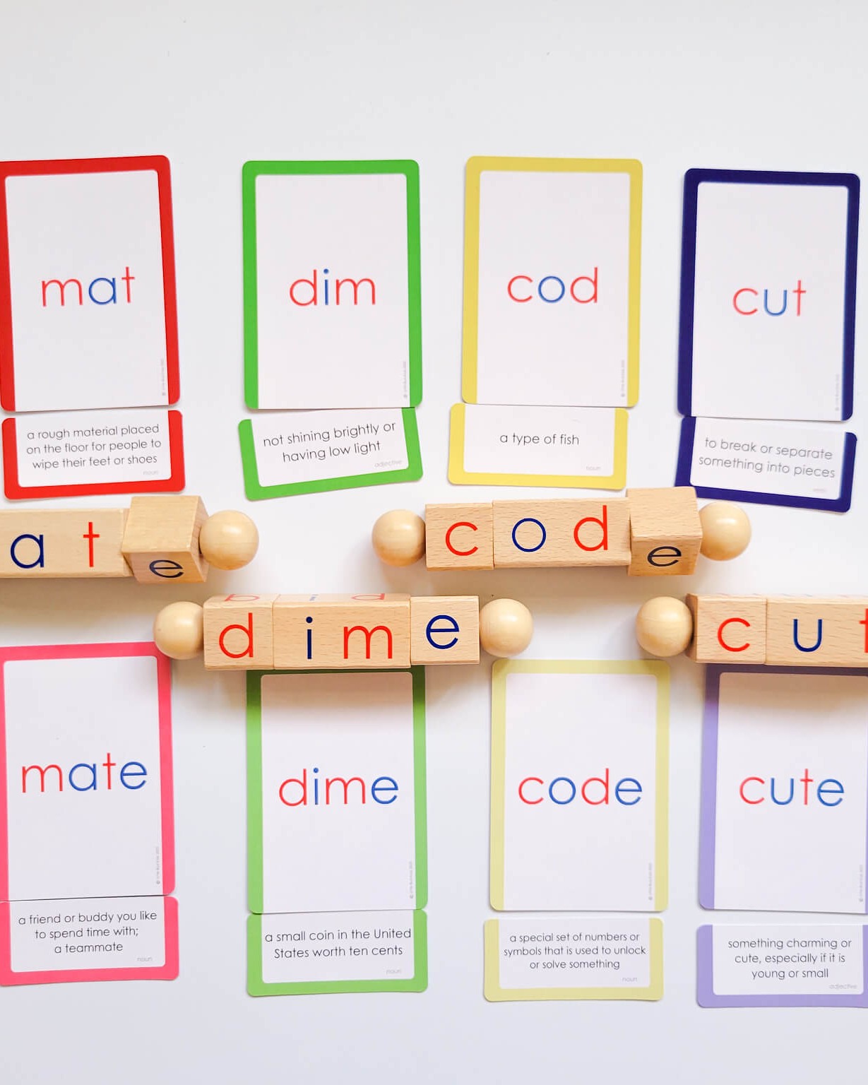 Silent E word definition cards and wooden spelling blocks for teaching CVCE word transformations includes words like mat, dim, cod, cut, mate, dime, code, and cute with matching visuals and definitions